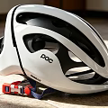 POC White Bicycle Helmet With Ventilation Holes And Red Blue Adjustment Straps