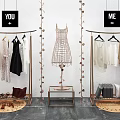 Modern Clothing Display Rack with Hanging Apparel Bags Shoes Decorative Plants and Black White Labels