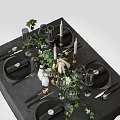 Elegant Tableware Set with Black Plates Wine Glasses Candles and Green Foliage