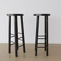 Two Black Bar Stools With Round Seats Ladder Style Legs White Wall Wooden Floor