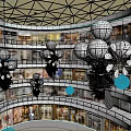 Multi Level Shopping Mall Interior With White Spherical Decorations And Plant Accents