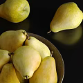 Fresh Ripe Pears Placed in Dark Bowl and Scattered Around on Black Background