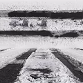Snow Covered Ground Surface With Vehicle Tracks And Packed Snow Patches