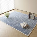 Blue Square Rug With White Textured Pattern And Vase Of Flowers Magazines On Wooden Floor