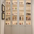 Glass Door Display Cabinet With Light Gray Frame And Multiple Shelves For Arranged Collectible Figures