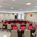 Modern Conference Room With Circular Table Red Signs Beige Chairs Ceiling Lights And Wall Emblem