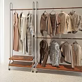 Stylish Clothes in Neutral Tones Hanging on Metal Racks with Wooden Bases