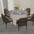 Modern Round Dining Table with Upholstered Gray Chairs Wooden Legs and Vase Flowers