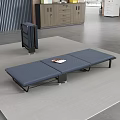 Portable Blue Folding Bed With Stripe Mattress Black Frame And Magazine On Top