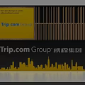 Trip.com Group Background Wall With Yellow Design Text Elements City Skyline Silhouette And Brand Logo