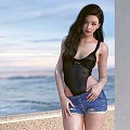 Woman in Black Bodysuit and Distressed Denim Shorts by Seaside Railing with Ocean View Sky