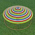 Colorful Striped Circular Photo Spot With Pillars On Green Grass Under Blue Sky