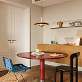 Dining Room With Red Round Table Blue Black Chairs Wooden Cabinets And Yellow Pendant Light