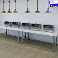 Unique Shaped Pendant Lights Above White Buffet Tables With Food Warmers In Restaurant