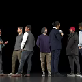 Group of Men Standing Together Casually Talking and Holding a Cup