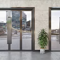 Modern Glass Entrance Doors With Metal Frames And Potted Plant Near Urban Buildings