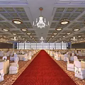 Luxurious Banquet Hall With Red Carpet Decorated Tables White Chair Covers And Chandeliers