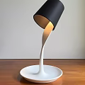 Modern Table Lamp with Black Shade White Curved Stem and White Base on Wooden Tabletop