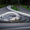 Stylish Garden Ornament Featuring Spiral Water Design Surrounded by Trees Grass and Stone Pathway