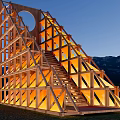 Scenic Illuminated Wooden Observation Deck With Geometric Design Over Grassland At Twilight Mountain Backdrop
