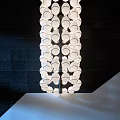 Elegant Contemporary Chandelier Featuring Multiple Circular Glass Lights Against Dark Wall