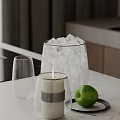 Inflatable Ice Bucket Filled With Ice Featuring Glass Cup Lit Candle And Green Apple On Table
