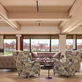 Inviting Lounge Area With Patterned Armchairs Sofa Pool Table Large Windows Green Lawn View Outside