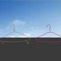 Two Gold Pink Metal Hooks With Blue Sky Background And Reflection