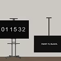 Two Black TVs on Stands Showing Digital Numbers and Paint It Black Text Against White Wall
