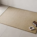 Square Beige Woven Rug on Light Tiles with White Wall and Box Magazine on Top