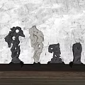 Stone Sculptures With Unique Holes And Irregular Shapes On Wooden Tabletop Light Wall With Shadows