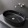 Black Marble Oval Washbasin With Silver Wall Mounted Faucet On Gray Countertop