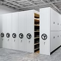 White Mobile Shelving Units With Black Circular Handles And Open Compartments In Industrial Storage Room