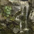 Scenic Garden Landscape Featuring Rockery Waterfall Green Plants And Pond