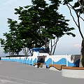 Blue And White Wavy Pattern Fence With Benches Trees And Waterfront View