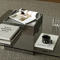 Modern Glass Coffee Table On Rug With Books Cup And Black Chair In Living Room