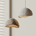 Two Hemispherical Concrete Pendant Lights With Warm Glow By Window Blinds