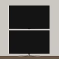 Sleek Black Modern Television With Metal Stand Against Light Colored Wall