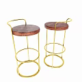Round Wooden Dining Table With Gold Metal Legs And High Stools With Coat Draped