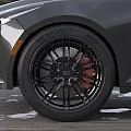 Car Tire With Black Alloy Wheels Red Brake Calipers And Tread Pattern On Wooden Deck