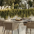 Outdoor Rattan Table And Chairs Set With Green Plant Backdrop And Decorative Tray
