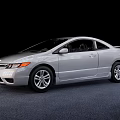 Silver Honda Two Door Coupe With Sleek Lines And Silver Wheels On Gray Carpet
