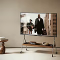 Modern Television On Wooden Rolling Stand With Side Table And Books