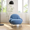 Blue Plush Rounded Lounge Chair With Black Metal Legs In Bright Room With Green Plant