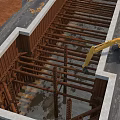 Construction Site Foundation Work In Progress With Yellow Excavator And Steel Beams