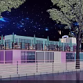 Vibrant Commercial Street at Night with Starry Sky Neon Signs and Waterfront Reflections