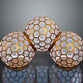 Three Honeycomb Patterned Spheres With Golden Frames And Transparent Interior On Reflective Surface