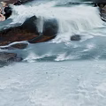 Natural Mountain Stream With Flowing Water And White Foam Over Rocks