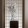 Abstract Silver Sculpture with Unique Curved Shapes on Pedestal Against Lattice Screen Background