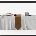 Elegant Massage Bed Setup With White Sheets Brown Towel And Stacked Towels